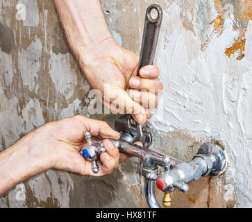 Cierre de llave ajustable en manos de fontanería, afloja la tuerca de  montaje en pared de suministro de agua de grifo de cocina con dos asas  Fotografía de stock - Alamy