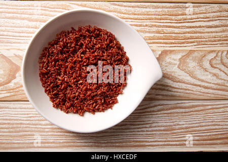 Rojo el arroz salvaje en una placa blanca sobre la plancha de madera Foto de stock