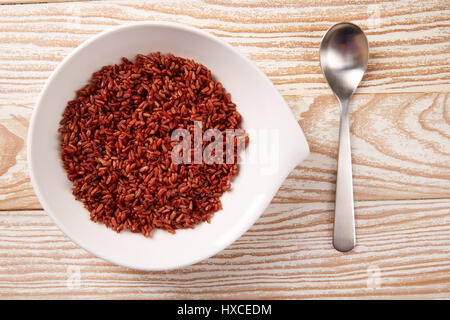 Rojo el arroz salvaje en una placa blanca sobre la plancha de madera Foto de stock