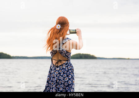 Finlandia, Pirkanmaa, Tampere, Mujer fotografiando mar