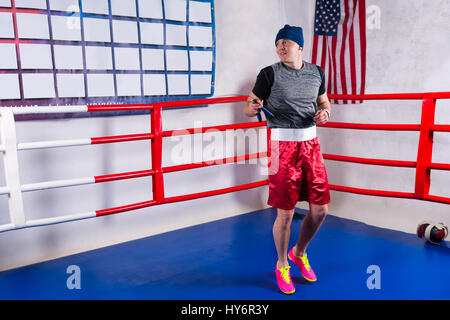 Boxer Masculino comba en un cuadrilátero regular rodeado por cuerdas en un  gimnasio Fotografía de stock - Alamy