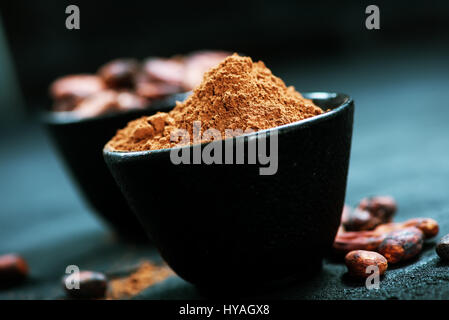 Cacao en grano y en polvo en el recipiente Foto de stock