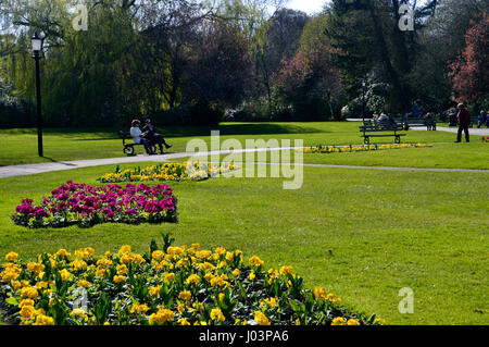 Una pareja sentada en un banco del parque en Jardines del Valle en la ciudad balneario de Harrogate, Yorkshire.UK.