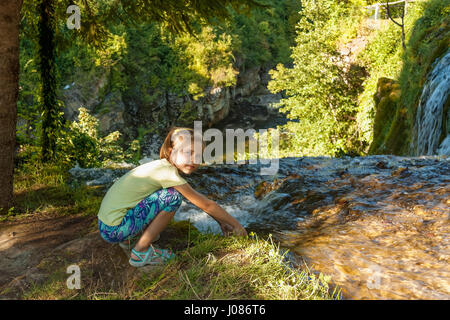 Chica por la catarata del río Slunjcica fluyen a Korana río Rastoke aldea cerca de Slunj, Croacia Foto de stock