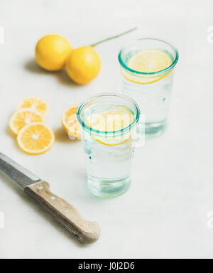 Mañana detox agua de limón en vidrios y limones frescos Foto de stock