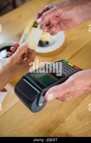 Senior mujer haciendo el pago a través de tarjeta de crédito en cafÃƒÂ© Foto de stock