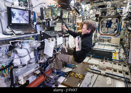 Expedición de la NASA 50 el primer miembro de la tripulación, el astronauta estadounidense Peggy Whitson controla el brazo robótico Canadarm2 desde a bordo de la Estación Espacial Internacional, mientras que los miembros de la tripulación Shane Kimbrough y Thomas Pesquet realizar una actividad extravehicular paseo espacial el 24 de marzo de 2017 en la órbita de la tierra. (Foto por NASA Foto /NASA via Planetpix) Foto de stock