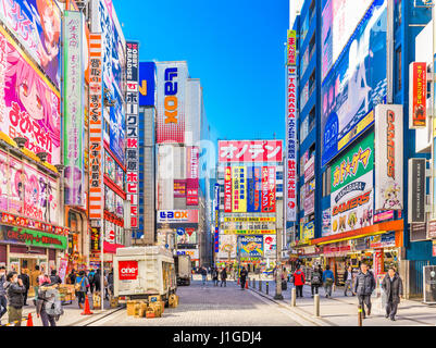 Tokio, Japón - Enero 11, 2017: Las multitudes pasan por debajo de coloridos carteles en Akihabara. El distrito histórico electrónica ha evolucionado hacia la zona comercial f Foto de stock