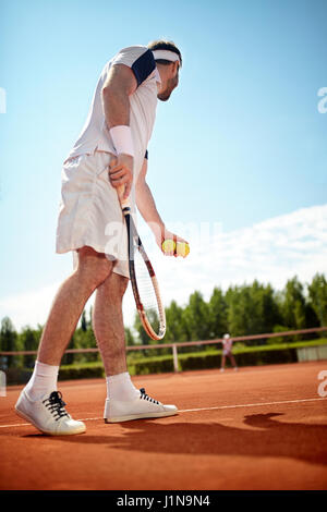 Deportista jugar tenis en la cancha de tenis Foto de stock