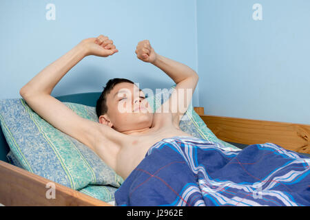 Los jóvenes caucásicos adolescente despertarse en la cama Foto de stock