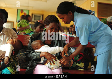 Malawi, Región Norte, Rumphi, Vigilancia de la Salud (HSA) Ayudante Estere Neba inmuniza a un niño con la vacuna en el Hospital del Distrito de Rumphi durante una sesión de atención posnatal Foto de stock