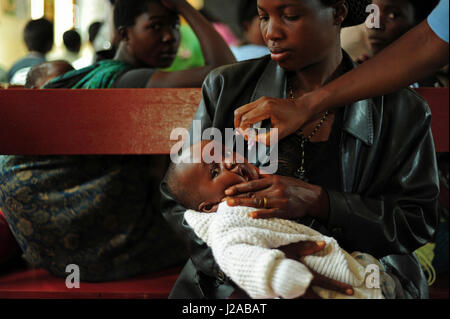 Malawi, Región Norte, Rumphi, Vigilancia de la Salud (HSA) Ayudante Estere Neba inmuniza a un niño con la vacuna de la poliomielitis en el Hospital de Distrito de Rumphi durante una sesión de atención posnatal Foto de stock
