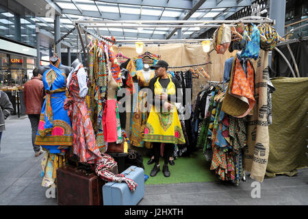 Un atractivo tall mujer trata sobre un africano vestido de impresión en Spitalfields Market, Londres, Reino Unido KATHY DEWITT Foto de stock