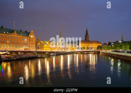 Vista nocturna de Christiansborg Palace y el edificio de la Bolsa a través del canal en Copenhague.