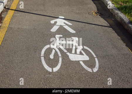 Señal de bicicletas blancas pintadas sobre el asfalto en el parque. Foto de stock