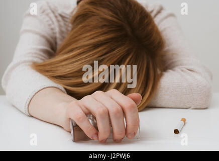 Mujer borracha durmiendo en la mesa y sosteniendo un vaso de cerveza en ...