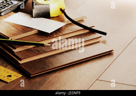Piso Laminado tablones y herramientas sobre fondo de madera Foto de stock