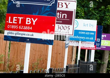 Agente inmobiliario 'por' signos anuncia tu propiedad en un suburbio de Londres.