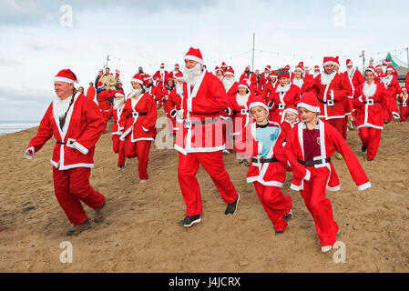 Perranporth, Cornualles, en el Reino Unido. El 18 de diciembre de 2016. Santa's en la arena una ejecución anual de caridad en Perranporth playa en Cornualles, Reino Unido Foto de stock