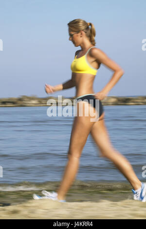 Mujer en ropa deportiva para correr en la arena