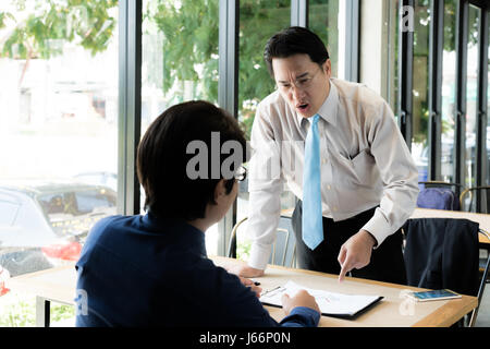Administrador de Asia del empresario quejándose a empleado por apuntando a él por error el trabajo, destacó la sensación en cafe office