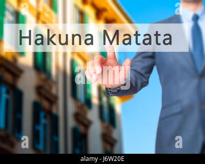 Hakuna Matata (frase swahili significa sin preocupaciones) - El empresario mano pulsando el botón en la interfaz de pantalla táctil. Negocios, tecnología, internet conce Foto de stock