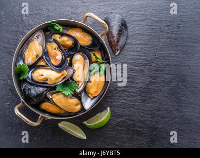 Mejillones hervidos en pan de cobre en el fondo de grafito.