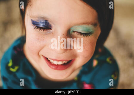 Retrato de una niña sonriente vistiendo la sombra de ojos