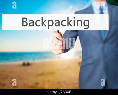 Backpacking - hombre de negocios mostrando signo. Negocios, tecnología, internet concepto. Stock Photo Foto de stock