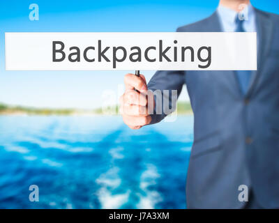 Backpacking - hombre de negocios mostrando signo. Negocios, tecnología, internet concepto. Stock Photo Foto de stock