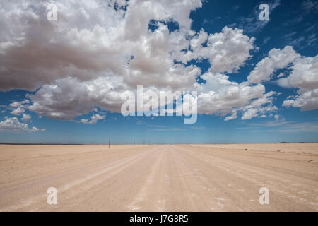 Imagen vibrante de la carretera del desierto y el azul cielo nublado