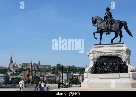 Hungría, Budapest. Estatua del Conde Gyula Andrassy cerca del edificio del Parlamento. Iglesia de Matías y Bastión de los Pescadores en el fondo. Foto de stock
