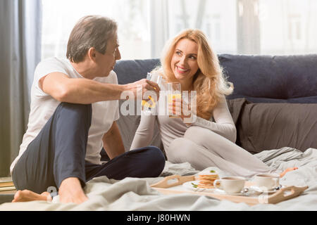 Feliz pareja de mediana edad desayunar juntos en la cama Foto de stock