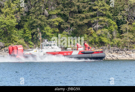 Un Canadian Coast Guard hovercraft velocidades junto con la línea de la costa de la isla Ruxton, en British Columbia's islas del Golfo. Foto de stock