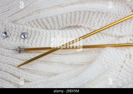 Prenda de punto hilo Blanco con color oro, agujas de tejer Foto de stock