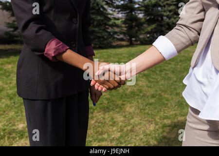 Primer plano de las manos. Dos mujeres agitando las manos después de mucho. Concepto de negocio. Foto de stock