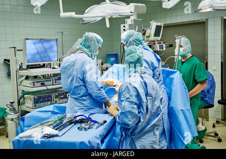 Equipo de cirujanos y enfermeros de realizar cirugía mínimamente invasiva laparoscópica Foto de stock
