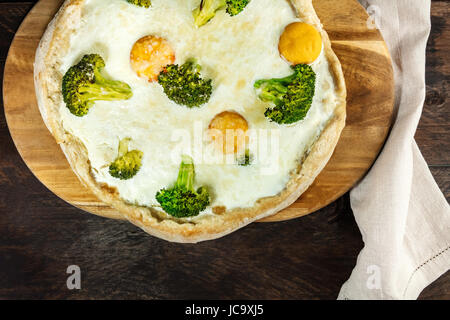 Huevo y brócoli pizza, disparó por encima de textura rústica Foto de stock