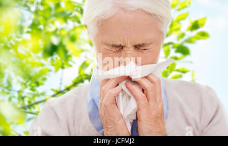 Enfermos altos mujer soplando la nariz a la servilleta de papel Foto de stock