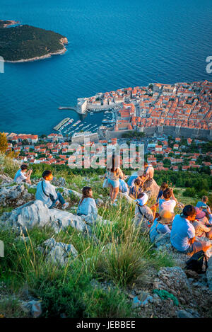 Los turistas observan la puesta de sol sobre el mar Adriático desde la cima del monte Srd, Dubrovnik. Foto de stock