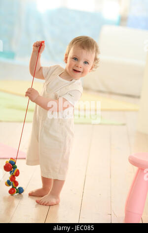 Interesados Curiosos Bebé Niño Niña En Mono Blanco Y Decoración De Lazo De  Pelo Se Arrastra En El Piso Mirando Sorprendido A La Cámara Sobre Fondo  Blanco. Concepto De Infancia Feliz Fotos