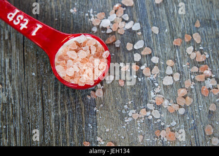 Cacito dosificador lleno de Rosa Himalayan Salt sobre fondo de madera rústica con espacio de texto Foto de stock
