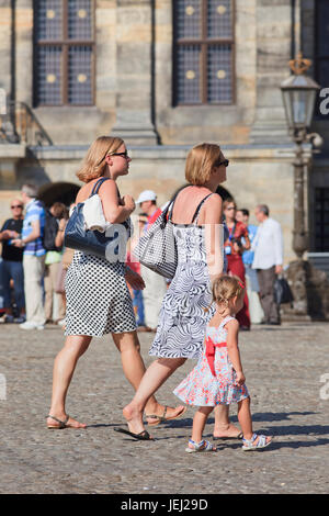 AMSTERDAM-19 DE AGOSTO DE 2012. Mujeres holandesas y un niño caminando por la Plaza Dam, un lugar famoso en el corazón de la ciudad, popular entre los turistas. Foto de stock