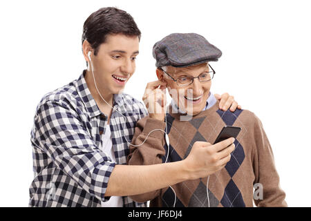 Nieto escuchando música en un teléfono con su abuelo aislado sobre fondo blanco. Foto de stock