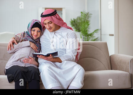 Los jóvenes de la familia árabe musulmana con la esposa embarazada esperando bebé Foto de stock
