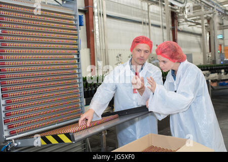 Compañeros mirando corchos en una fábrica de vino
