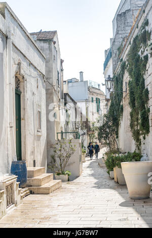 Calle angosta en blanco romántico ciudad de Ostuni, Puglia, Italia Foto de stock