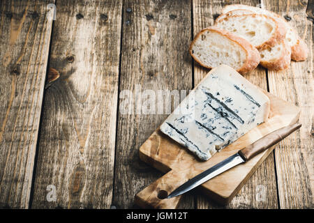 Queso Gorgonzola con pan ciabatta en madera rústica junta de corte Foto de stock