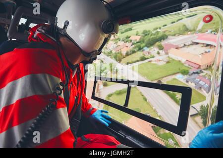 Alarma para helicópteros de servicios médicos de emergencia. Doctor en busca de ventana a la calle. Tema de rescate, ayuda y esperanza.