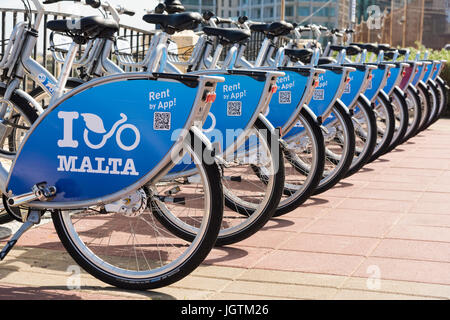 Yo Malta alquilar bicicletas o motos alineadas en un ciclo rack en Malta